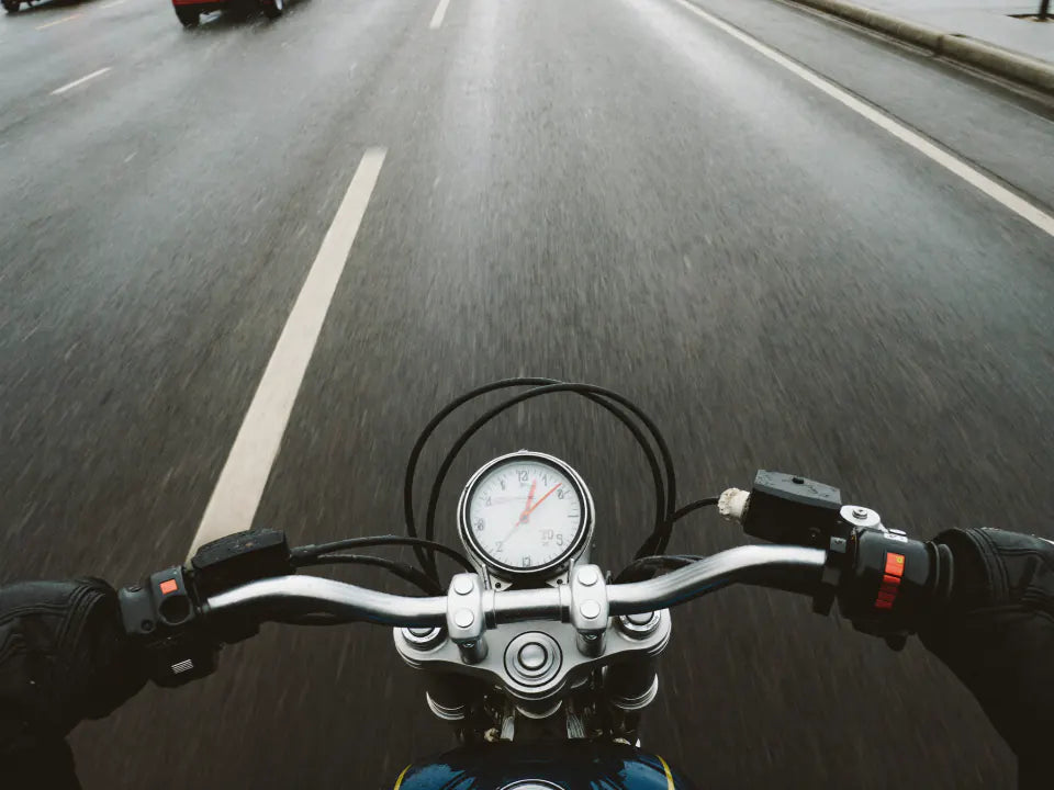 Rider's view over the handlebars on a wet carriageway in sleet