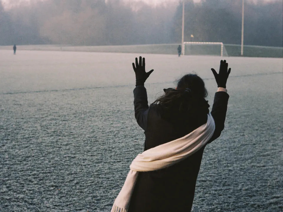 Standing at the edge of a frosty playing field on a cold morning